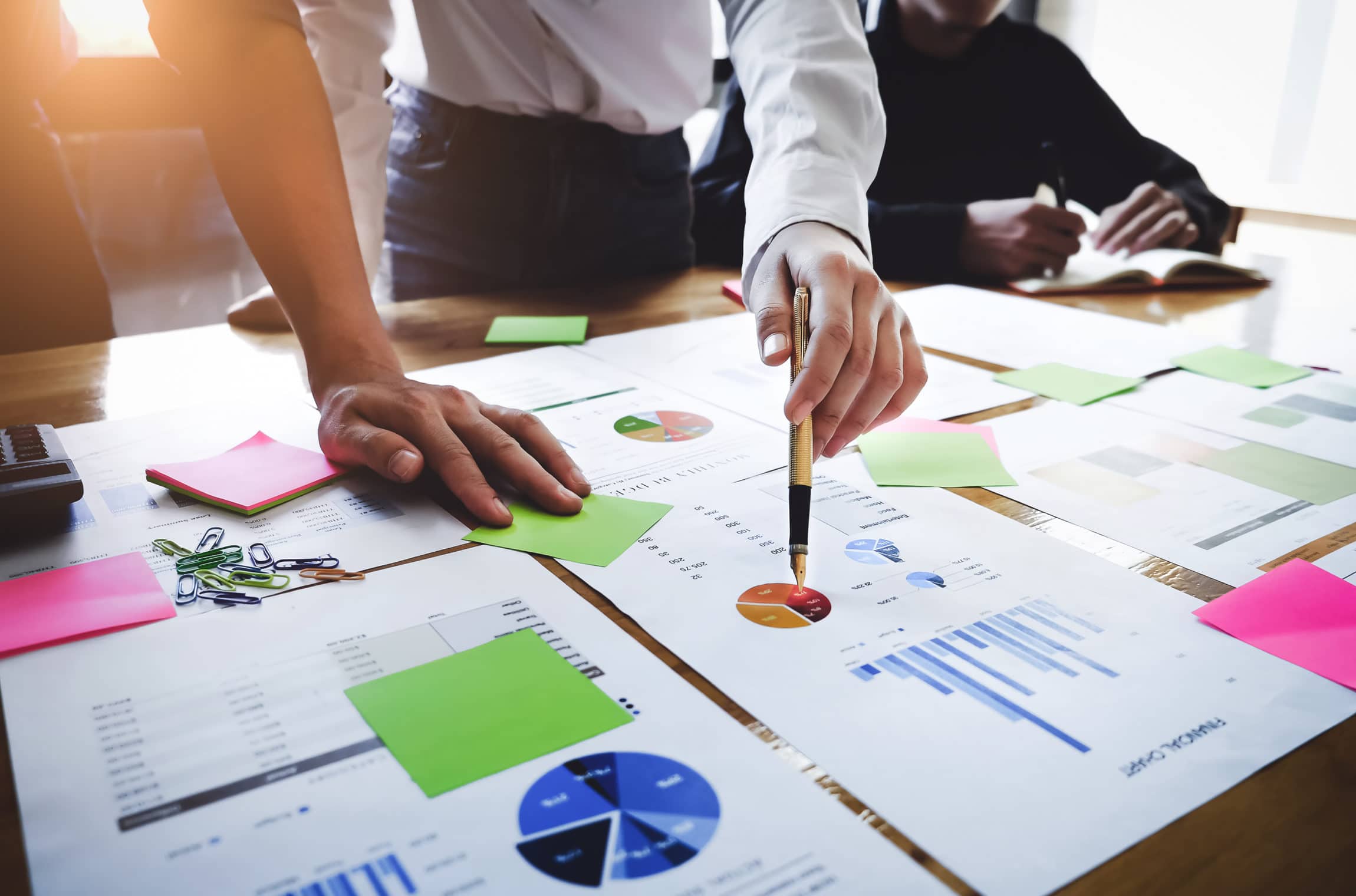 Business woman analyzing KPIs through charts and graphs on a large table