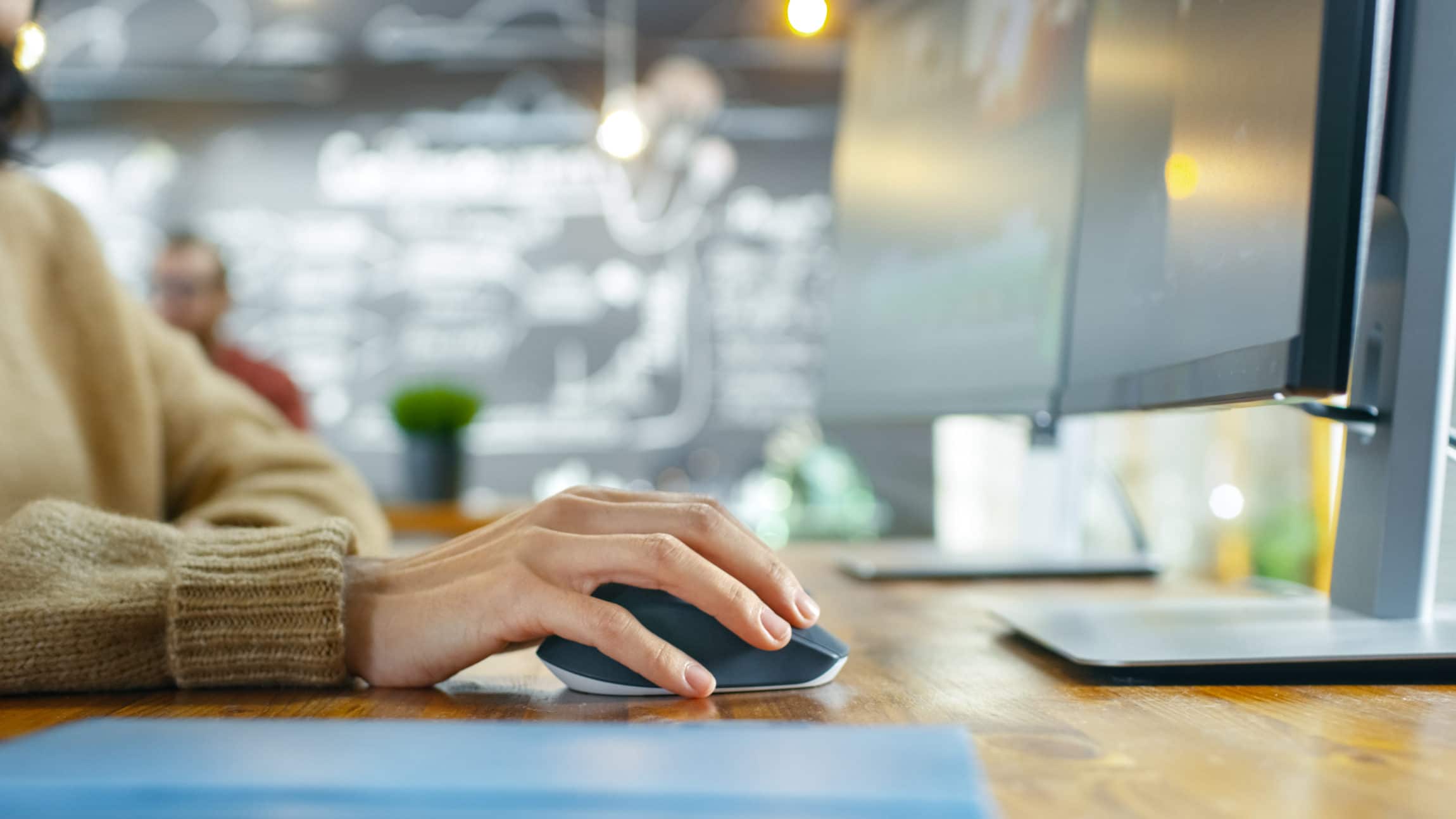 Photograph of a woman using a computer at a desk.